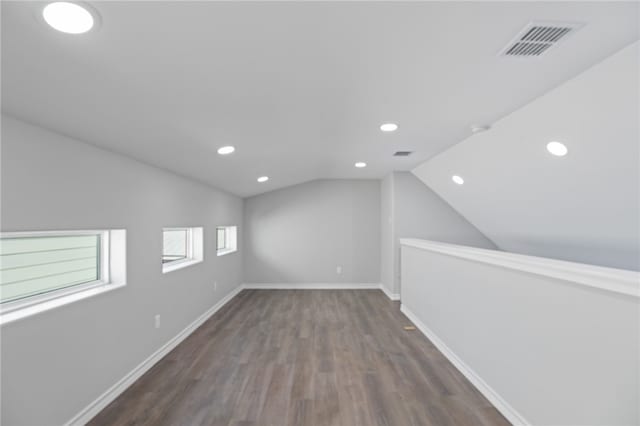 additional living space with dark hardwood / wood-style flooring and vaulted ceiling