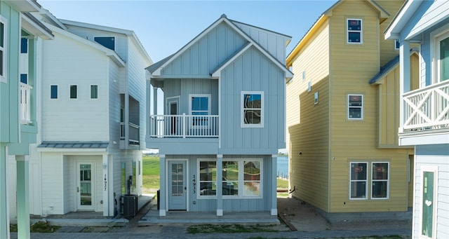 rear view of property with central AC unit and a balcony