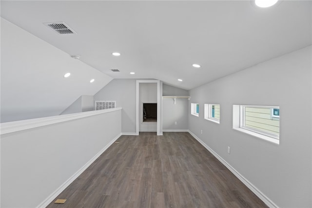 additional living space with dark hardwood / wood-style floors and vaulted ceiling