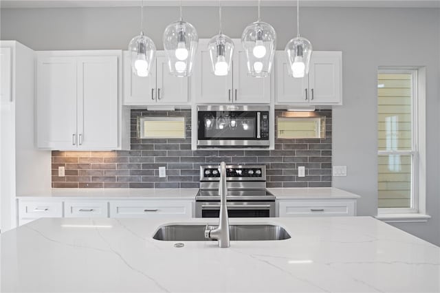 kitchen featuring appliances with stainless steel finishes, light stone counters, and white cabinets