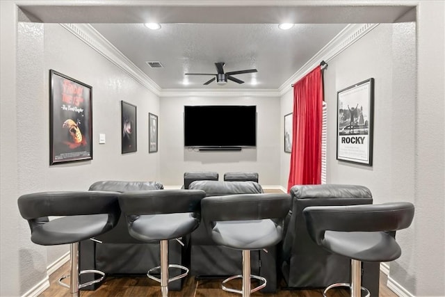 home theater featuring visible vents, crown molding, a dry bar, and ceiling fan