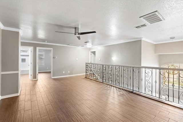 spare room featuring ceiling fan, wood finished floors, and visible vents