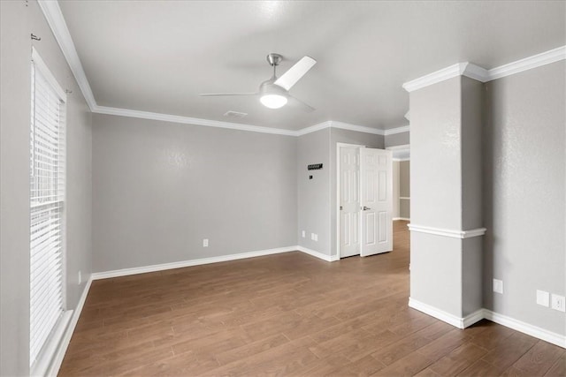 unfurnished room with ceiling fan, baseboards, wood finished floors, and crown molding