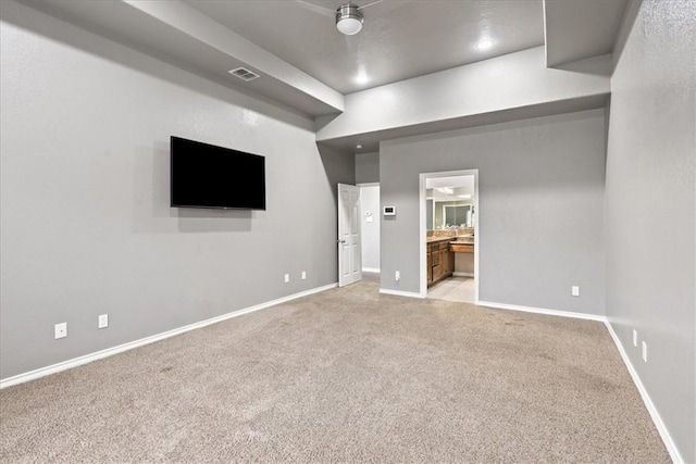 unfurnished bedroom featuring light carpet, connected bathroom, visible vents, and baseboards