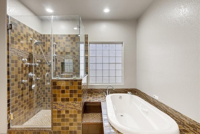 full bathroom with a stall shower, a bath, and recessed lighting