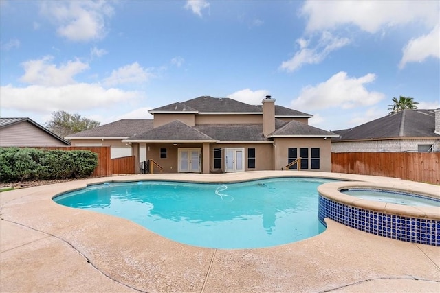 view of pool featuring a patio, french doors, a fenced backyard, and a pool with connected hot tub