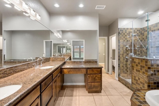 bathroom with visible vents, toilet, a stall shower, a sink, and tile patterned floors