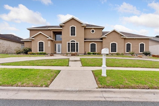 view of front of house with stucco siding and a front yard