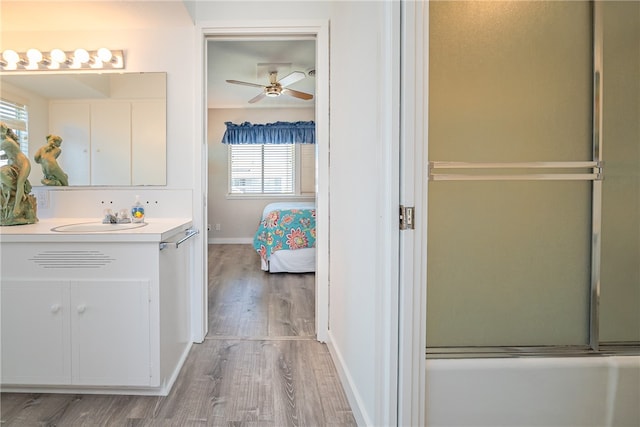 bathroom with vanity, hardwood / wood-style flooring, a shower with door, and plenty of natural light