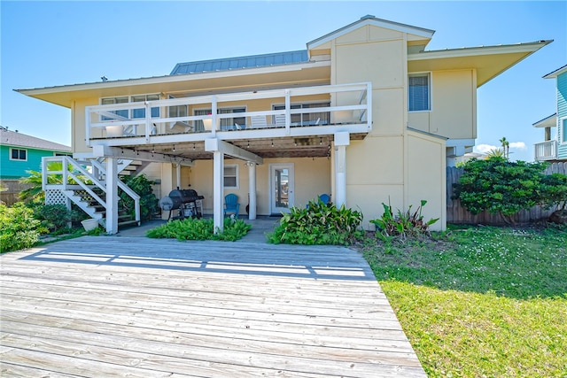 back of property featuring a wooden deck, a yard, and a patio area