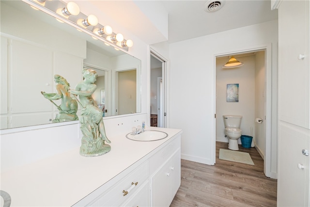 bathroom featuring hardwood / wood-style floors, vanity, and toilet