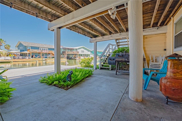 view of patio featuring a water view and a boat dock