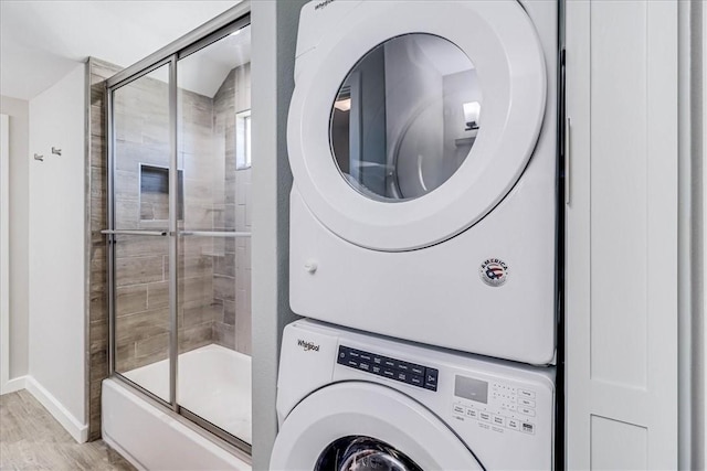 washroom featuring light wood-type flooring and stacked washer and clothes dryer