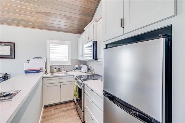 kitchen featuring backsplash, stainless steel appliances, sink, wooden ceiling, and white cabinetry