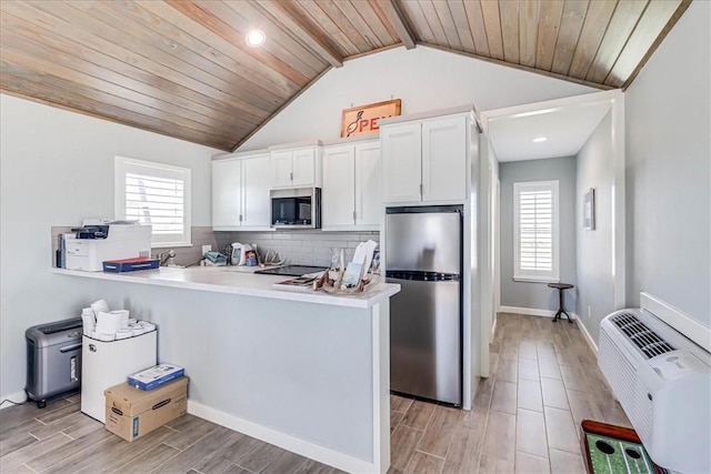 kitchen featuring vaulted ceiling with beams, tasteful backsplash, white cabinetry, stainless steel appliances, and wood ceiling