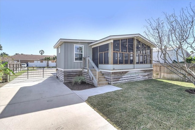 manufactured / mobile home featuring a sunroom and a front yard