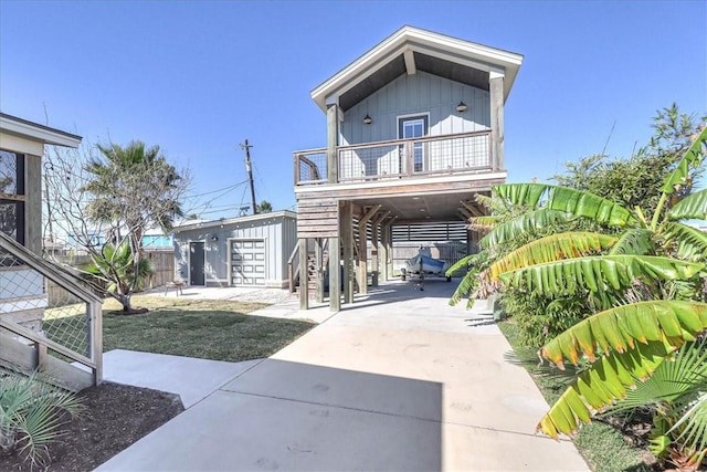 view of front of home with a carport, a garage, an outdoor structure, and a balcony