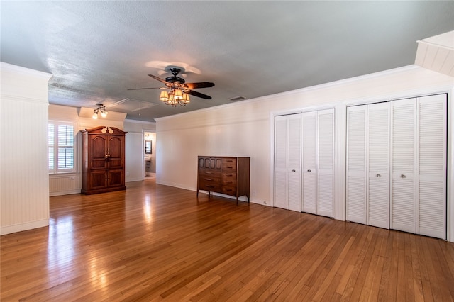 unfurnished living room featuring ornamental molding, light hardwood / wood-style flooring, a textured ceiling, and ceiling fan