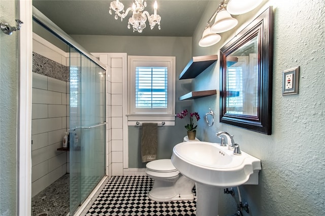 bathroom with a chandelier, a textured ceiling, toilet, and a shower with shower door