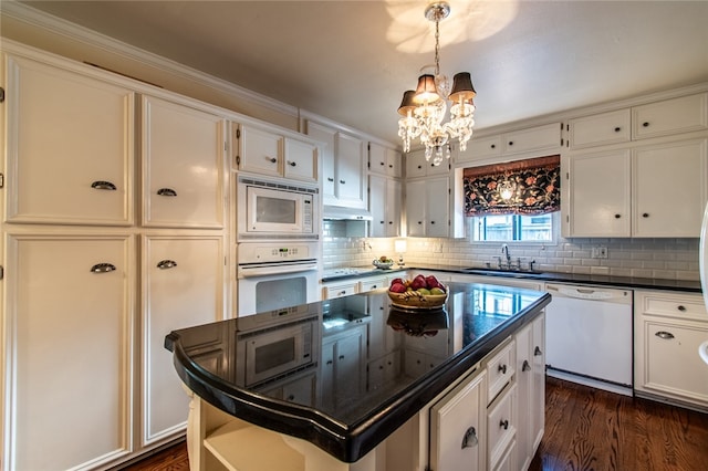 kitchen with white cabinetry, hanging light fixtures, sink, white appliances, and a center island