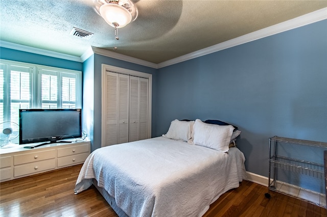 bedroom with a closet, wood-type flooring, ornamental molding, a textured ceiling, and ceiling fan