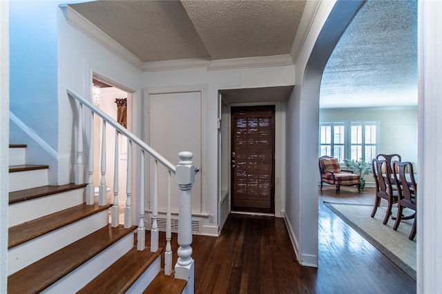 entrance foyer with a textured ceiling, dark hardwood / wood-style floors, and crown molding