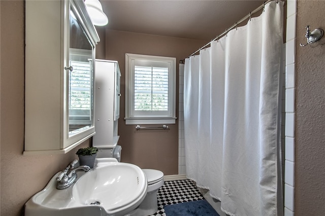 bathroom with curtained shower, sink, and toilet