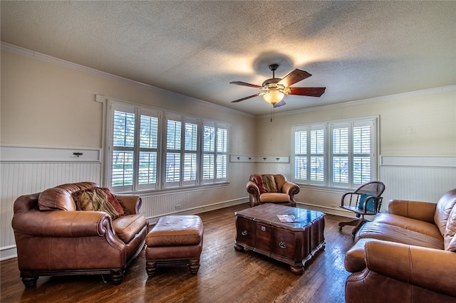 living room featuring dark hardwood / wood-style flooring, a wealth of natural light, a textured ceiling, and ornamental molding