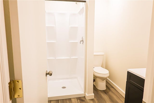 109 Dewey Ave, Alice, TX 78332 - bathroom featuring a stall shower, wood finished floors, toilet, vanity, and baseboards