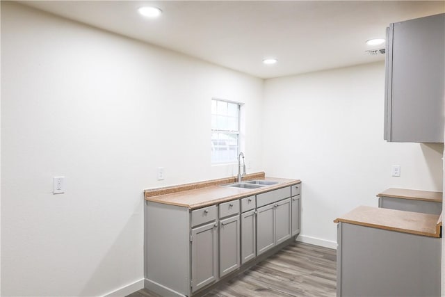 109 Dewey Ave, Alice, TX 78332 - kitchen featuring gray cabinetry, a sink, light wood-type flooring, baseboards, and recessed lighting