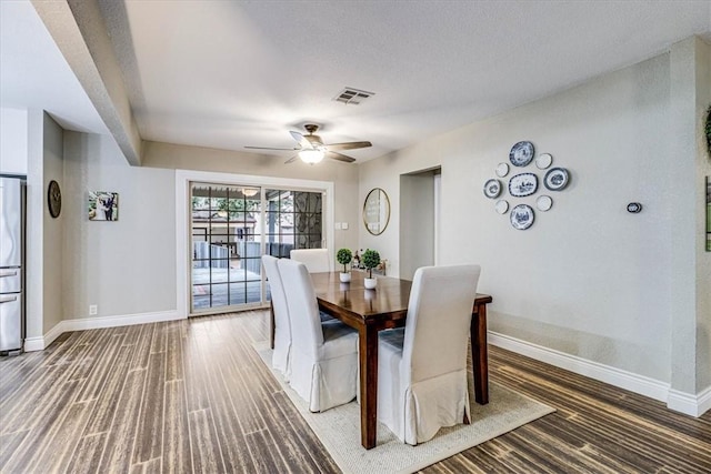 dining space featuring dark wood-type flooring, a textured ceiling, and ceiling fan