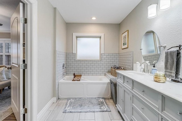 bathroom with vanity and a washtub