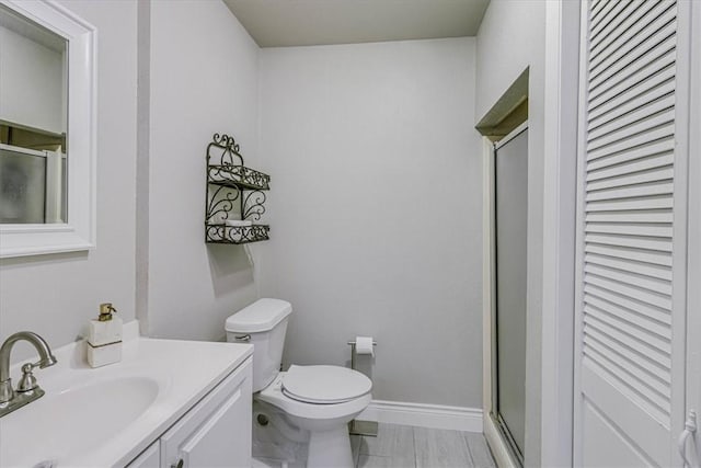 bathroom with vanity, toilet, and a shower with shower door