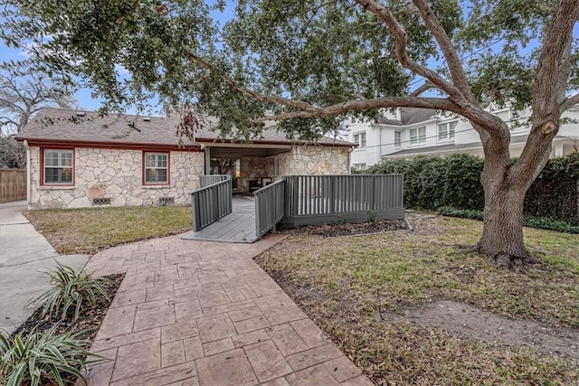 rear view of house with a deck and a lawn