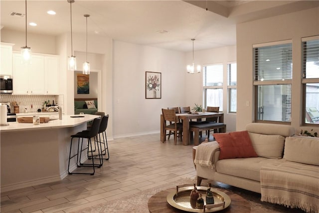 living room with light wood-type flooring and a chandelier