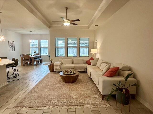 living room featuring a tray ceiling, light hardwood / wood-style flooring, and ceiling fan