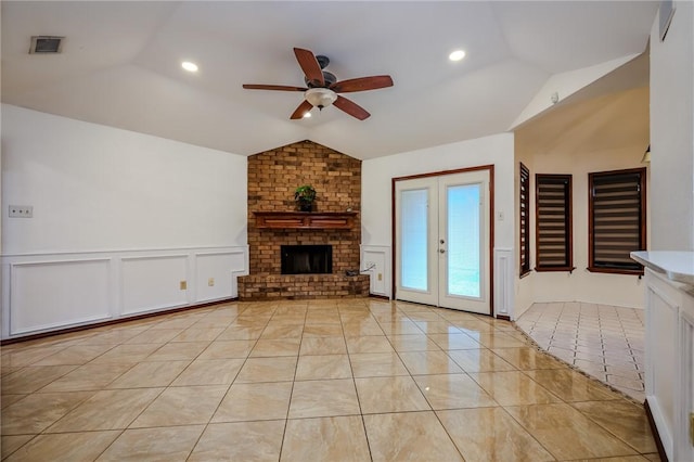 unfurnished living room featuring ceiling fan, lofted ceiling, a fireplace, and french doors