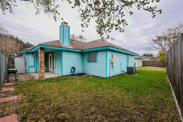 rear view of property featuring central AC and a yard