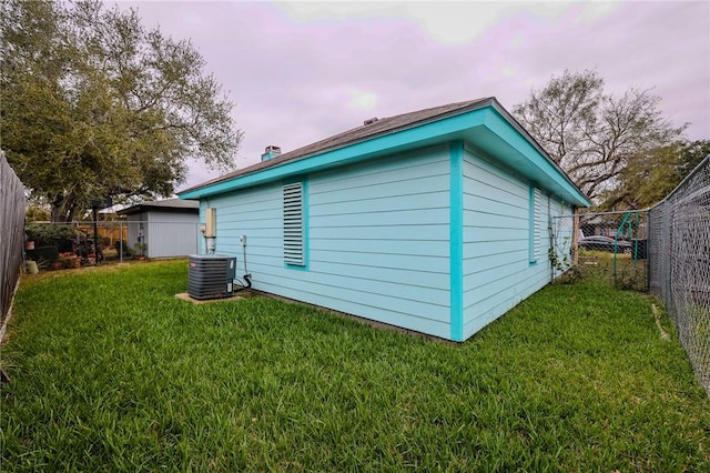 property exterior at dusk with a lawn and central air condition unit