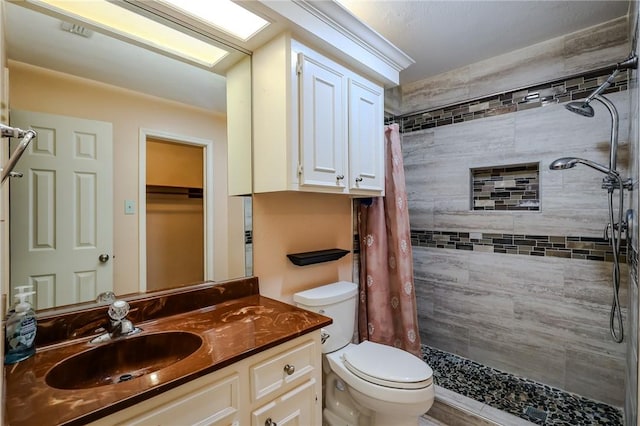 bathroom with a shower with shower curtain, vanity, and toilet