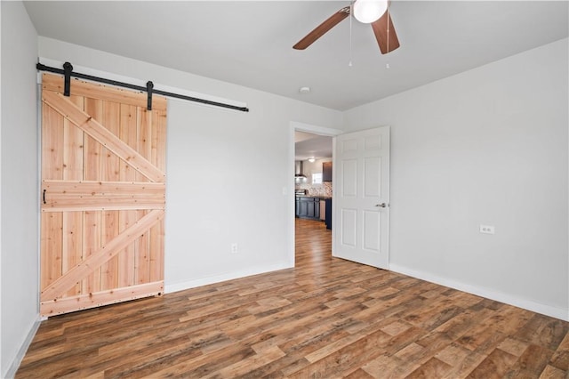 2914 Debra, Corpus Christi, TX 78418 - spare room featuring a barn door, ceiling fan, wood finished floors, and baseboards