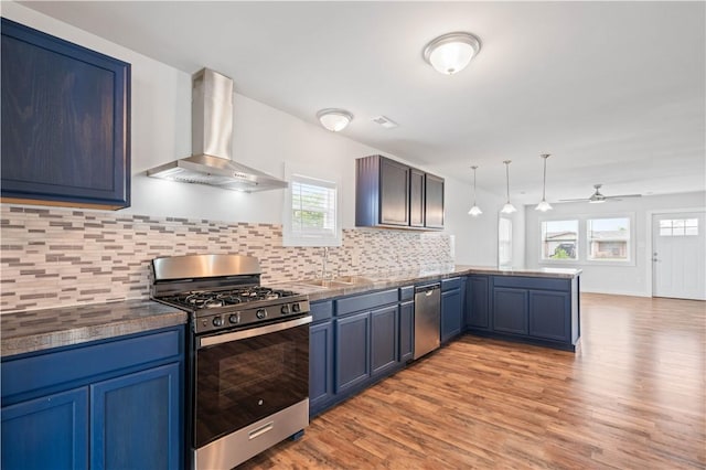 2914 Debra, Corpus Christi, TX 78418 - kitchen featuring wall chimney exhaust hood, light wood finished floors, a peninsula, and stainless steel appliances
