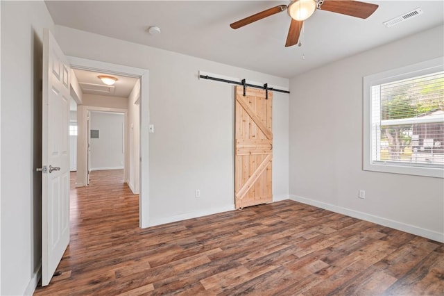 2914 Debra, Corpus Christi, TX 78418 - unfurnished bedroom with wood finished floors, visible vents, a barn door, and baseboards