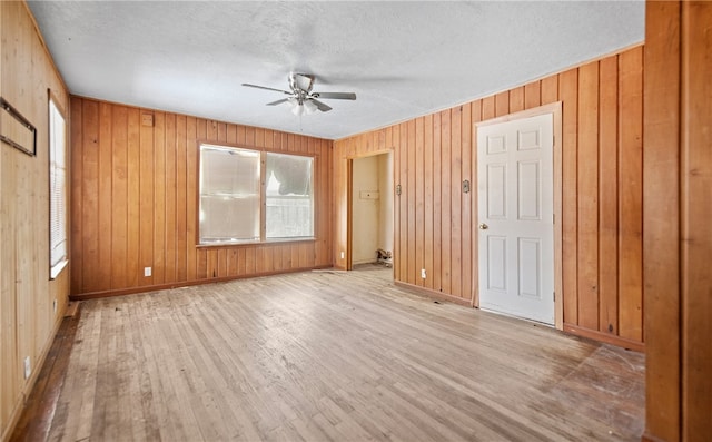 4833 Larcade Dr, Corpus Christi, TX 78415 - empty room with wood finished floors, a ceiling fan, wood walls, and a textured ceiling
