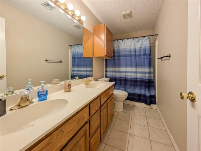 14929 Red River Dr, Corpus Christi, TX 78410 - bathroom featuring toilet, double vanity, a textured ceiling, tile patterned floors, and a shower with curtain