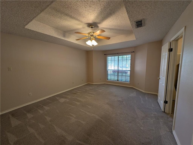 14929 Red River Dr, Corpus Christi, TX 78410 - empty room featuring dark carpet, a ceiling fan, a raised ceiling, and a textured ceiling