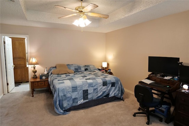 14929 Red River Dr, Corpus Christi, TX 78410 - carpeted bedroom featuring a textured ceiling, a tray ceiling, baseboards, ceiling fan, and a desk