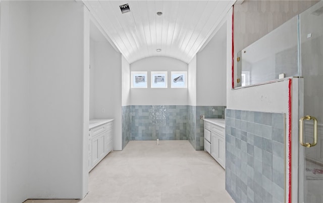 758 Buffalo Creek Dr, Corpus Christi, TX 78415 - full bathroom featuring tile walls, vanity, vaulted ceiling, a stall shower, and wainscoting