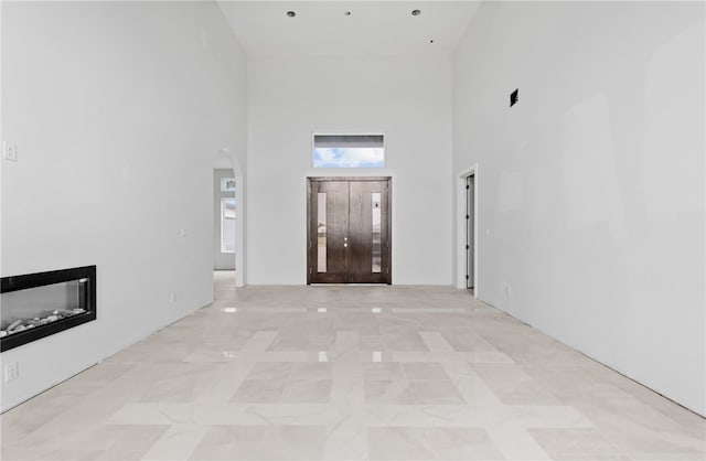 758 Buffalo Creek Dr, Corpus Christi, TX 78415 - foyer entrance featuring a towering ceiling, a glass covered fireplace, arched walkways, and light marble finish floors