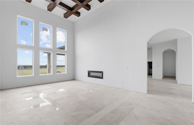 758 Buffalo Creek Dr, Corpus Christi, TX 78415 - spare room with a towering ceiling, coffered ceiling, a fireplace, beamed ceiling, and arched walkways